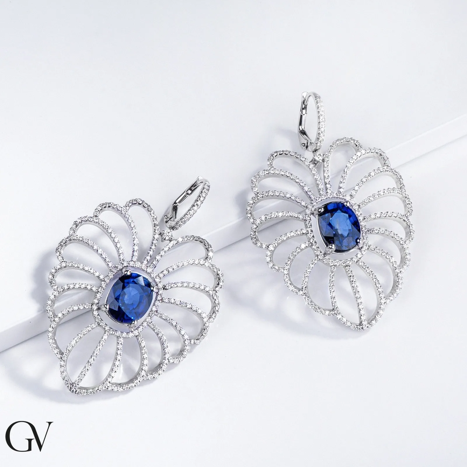 Orecchini in oro bianco 18k con grande pendente ovale in diamanti e zaffiro blu.